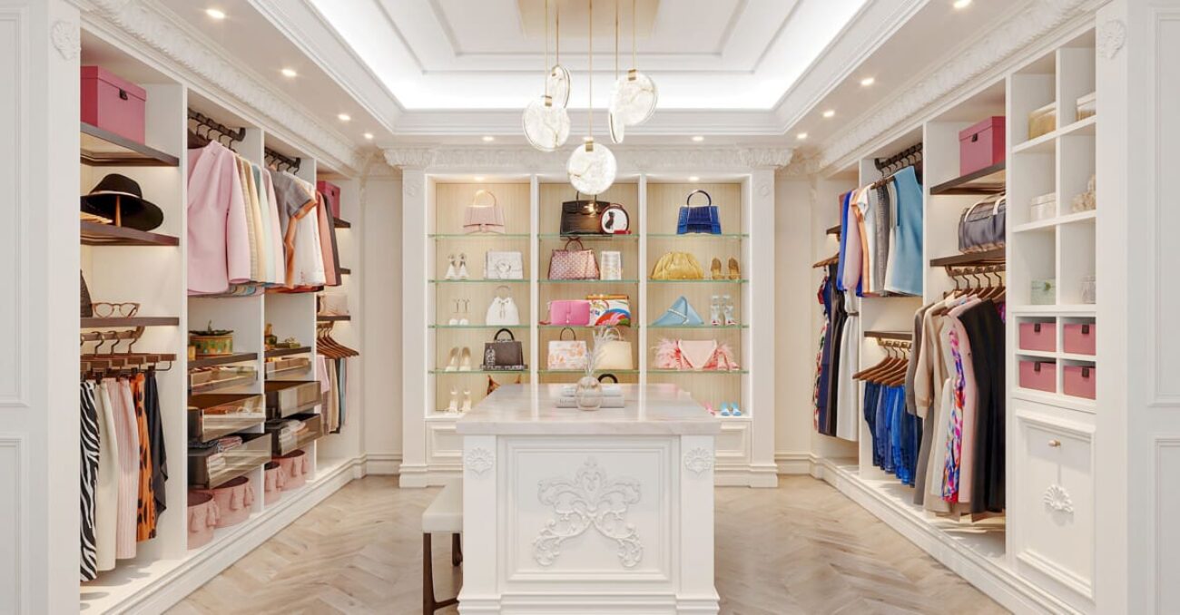 White walk-in closet with ornate trim and crown molding, featuring glass shelving