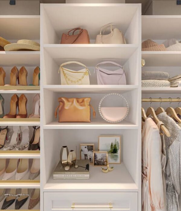 Soft neutral-toned boutique-style closet with white built-ins, open shelving for shoes, purses, and hats