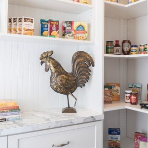 Charming pantry with white beadboard walls and marble counters