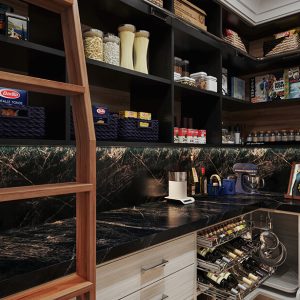 Pantry with black cabinetry, marble-look counters, woven baskets, and a wooden ladder for high shelf access.