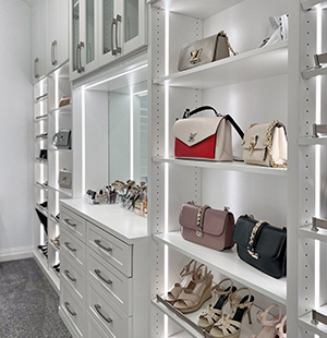 Custom walk in closet with LED lighting strips and purse display Closet Factory DFW