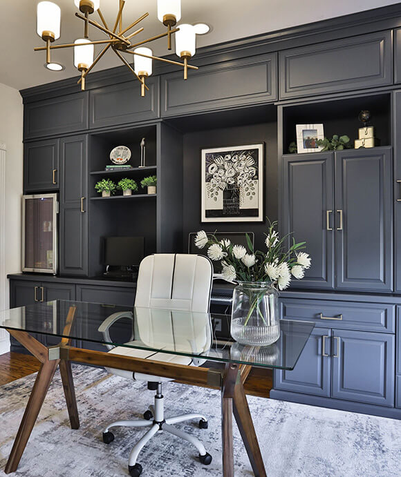 Sophisticated home office with custom built-in cabinetry in matte navy, open shelving, and brass hardware