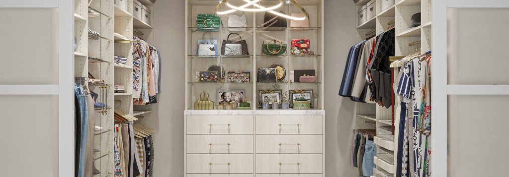 Custom walk in closet with white drawers and glass display shelving Closet Factory Greenville