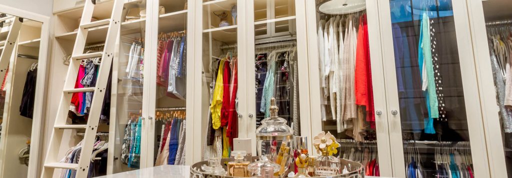 Custom reach in closet with glass front doors by Closet Factory Houston