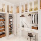 High-end laundry and utility room featuring built-in cabinetry with fluted glass doors, concealed storage