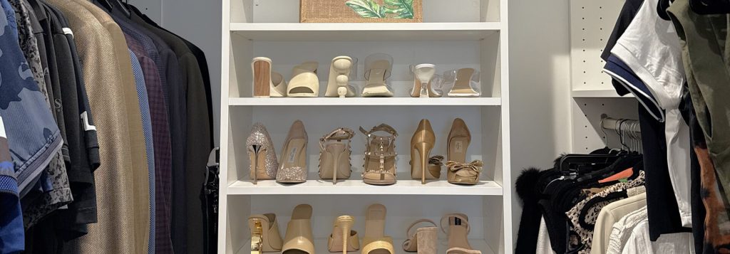 Closet shelving unit featuring a curated collection of designer heels in neutral tones, flanked by men's and women's clothing neatly organized on hanging rods