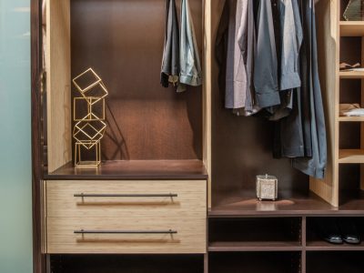 Reach-in closet in Summer Breeze with Cocoa backing. Includes open shelving, cubbies for folded clothing, and drawers with long matte black bar pulls.