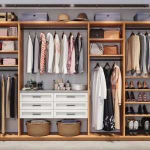Dual-tone reach-in closet system in Tea for Two with White Chocolate drawers with black hardware. Featuring pull-out pant rack, adjustable shelving, and angled shoe shelves.