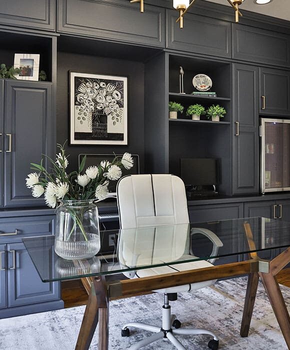 Custom home office system with upper and lower cabinetry, glass display doors, and crown molding.