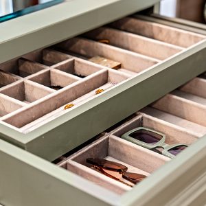 Soft-lined drawer organizer in a sage green finish holding sunglasses and accessories