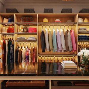 Upscale walk-in closet with a waterfall marble island, velvet-lined jewelry drawers, tiered hanging rods, and personalized accessories display shelves.