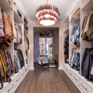 Elegant white closet with symmetrical shelving, brass drawer handles