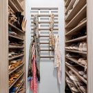 Shoe shelving display with adjustable rows and a wall-mounted rack for scarves and belts.