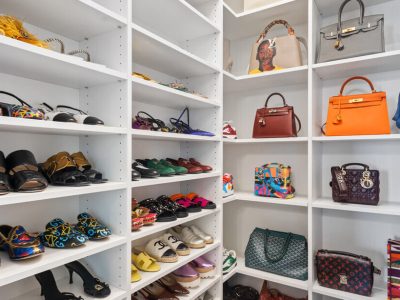 Accessory organization in closet with white gloss shelving for shoes and purses