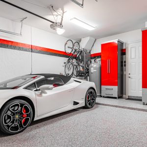 Luxury sports garage with high-gloss red cabinetry, gray base drawers, and vertical bike racks