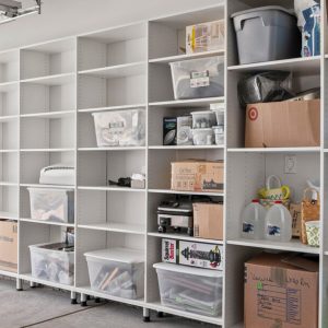 Garage wall with full-height white cabinetry, open cubbies