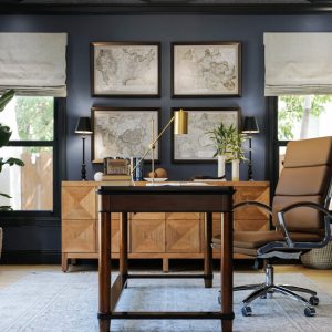 Executive-style home office with fluted drawer fronts, integrated file storage, custom base cabinets, and library lighting