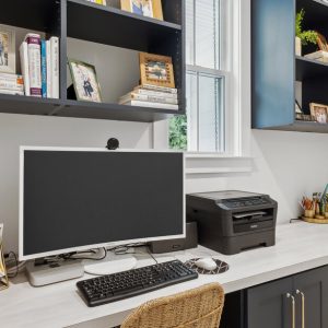 Compact built-in home office with durable worksurface, vertical cubby shelving, and concealed drawers