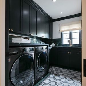 Custom laundry room with black high gloss cabinetry and laundry sink