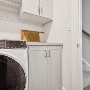 Custom laundry room storage with shaker cabinets