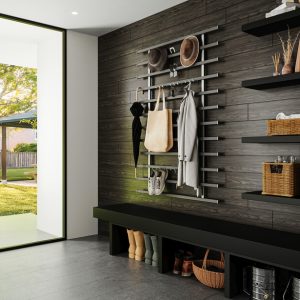 Modern mudroom with a black bench, black wood-paneled wall, and minimalist metal peg system for coats and hats