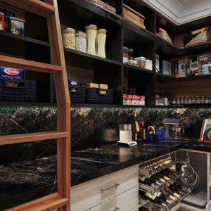 Upscale pantry with black cabinetry, integrated ladder, deep green stone countertops, organized baskets, and metal pull-out storage for wine and cookware.