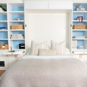 Custom Murphy Bed with white built-in cabinetry and pull-out desk with strip lighting