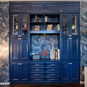 Elegant navy blue built-in cabinetry with glass doors and open shelving