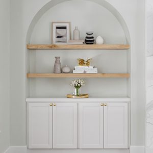 Modern alcove wall unit with light wood floating shelves and white lower cabinetry