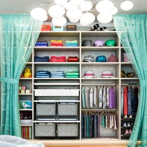 Children's closet with double handing rods and quilted fabric pull-out baskets.