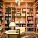 Built-in shelving featuring built-in window seat and work desk, slanted book display shelf, and a rolling ladder for added accessibility.