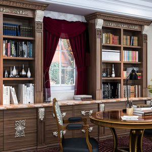 Traditional library built-ins with ornate trim and crown molding, carved corbels, and inset panel doors.