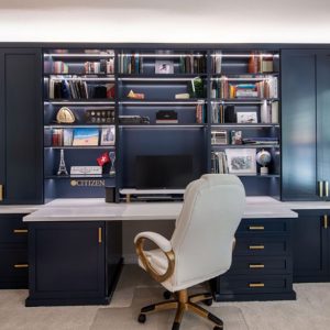 Built-in desk with side full height cabinets and open book shelving with LED light strips.