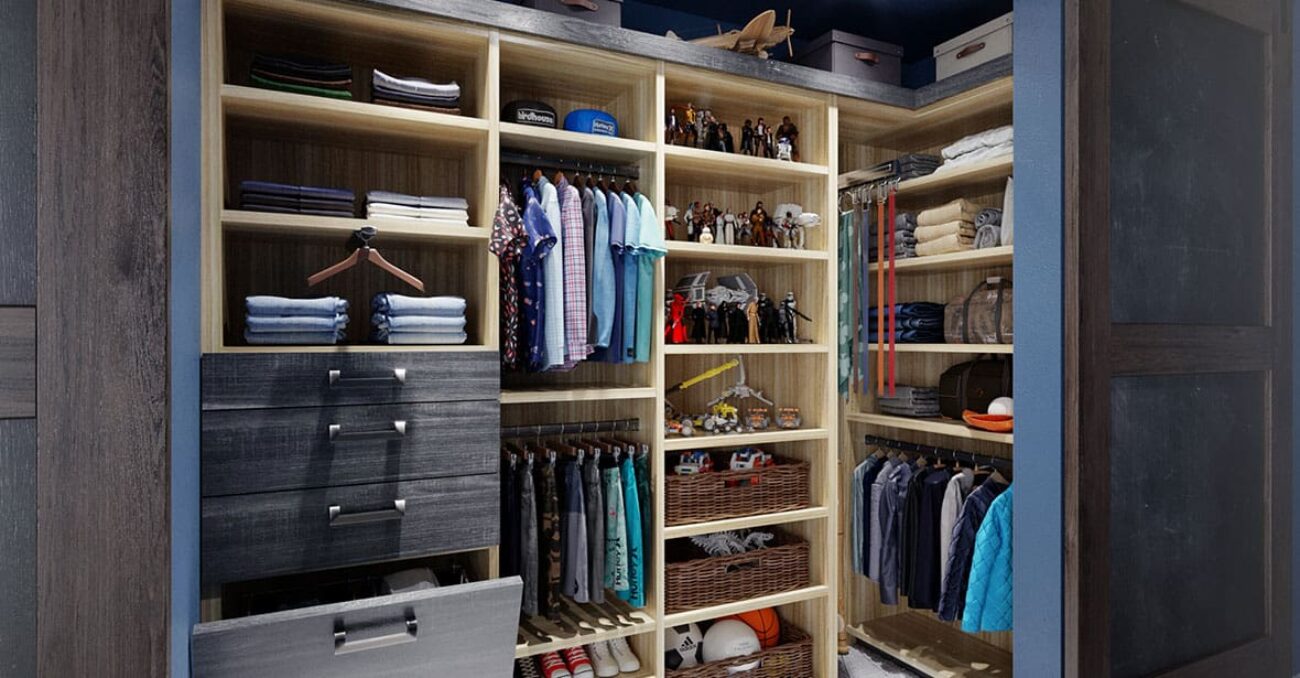 Children's clothing in reach-in closet featuring pull-out tie rack, dual level hanging rods, upper storage, and woven baskets.