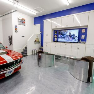 High-gloss white garage storage cabinetry with integrated TV mount.