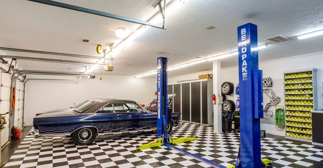 Stylized garage system with black melamine cabinetry, open shelving, and slatwall organizer.