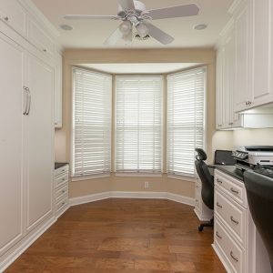 Home office with built-in wall bed to transform space into guest room. Dual work stations built in with raised panel cabinet doors.