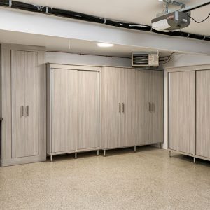 Garage cabinetry with sliding doors and workstation drawers on wheels for easy mobility.
