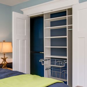 Reach-in closet with pull out wire baskets and dual hanging rods.